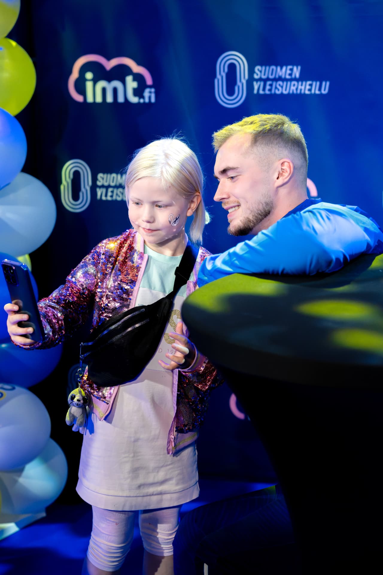 Nuori fani ottaa selfien yleisurheilijan kanssa meet & greet -tilaisuudessa